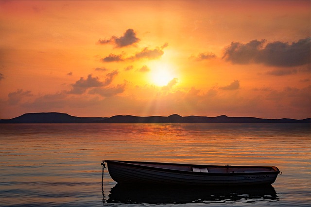 夕日の海に浮かぶ小船